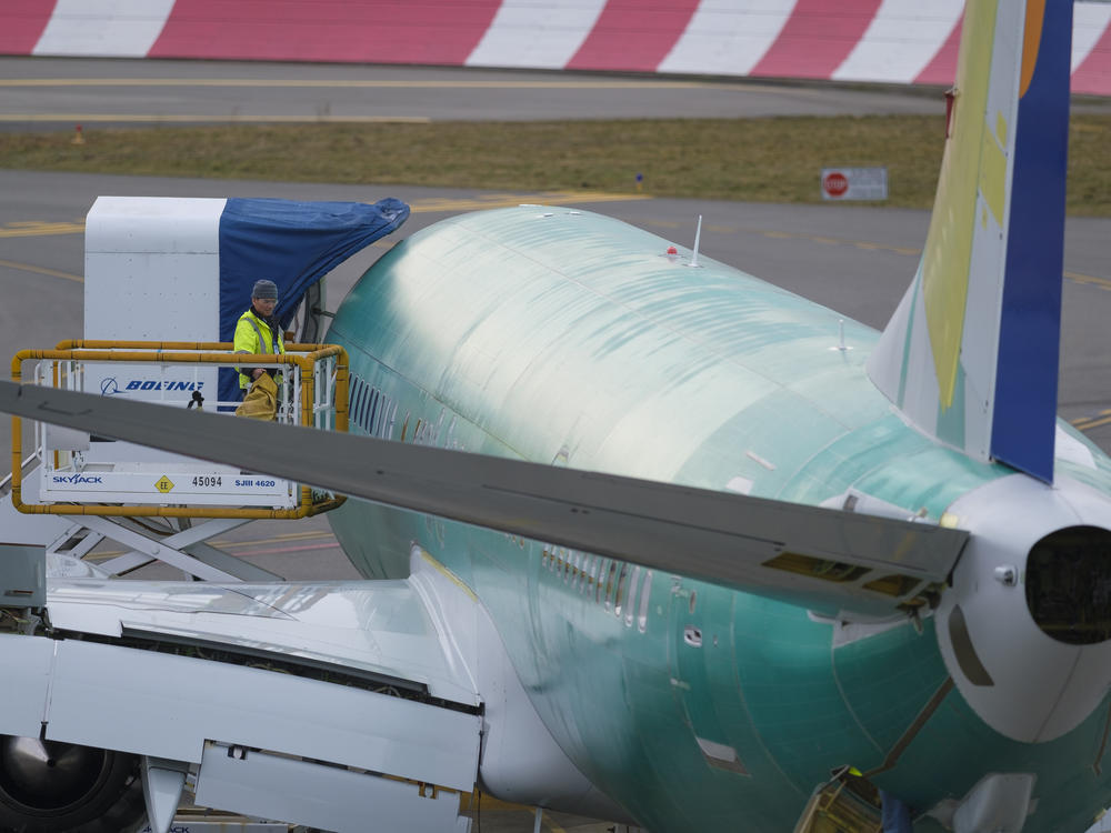 An employee checks a Boeing 737 Max 9 airplane from a lift outside the company's factory, on March 14, 2019 in Renton, Wash.