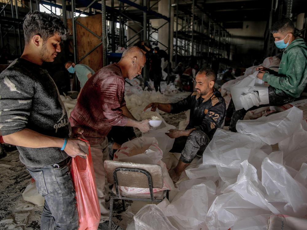Workers ration out flour during the distribution of humanitarian aid in Gaza City on March 17.