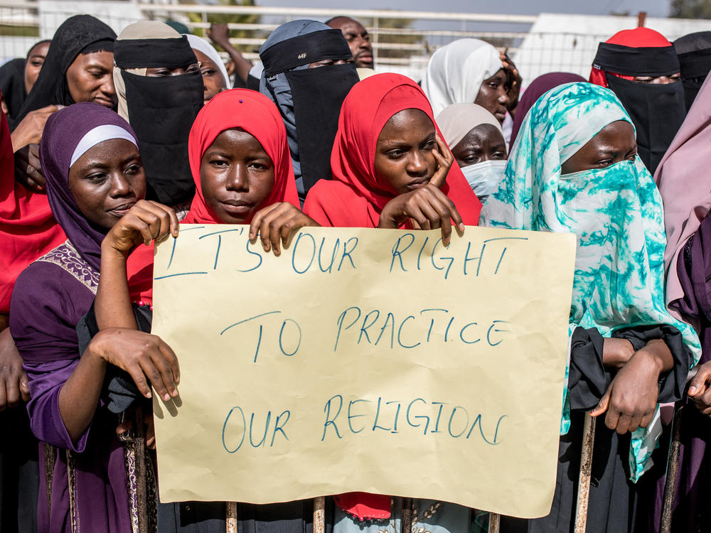 Opponents of the ban on female genital mutilation (FGM) gather outside the National Assembly in Banjul, The Gambia, on March 18, 2024. Lawmakers voted to advance a highly controversial bill that would lift the ban on FGM.