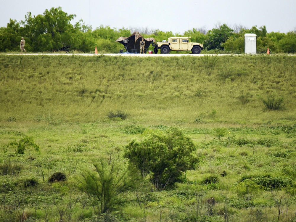 Two members of the National Guard patrol an area of land behind the federal border wall Tuesday evening, March 19in Mission, Texas.