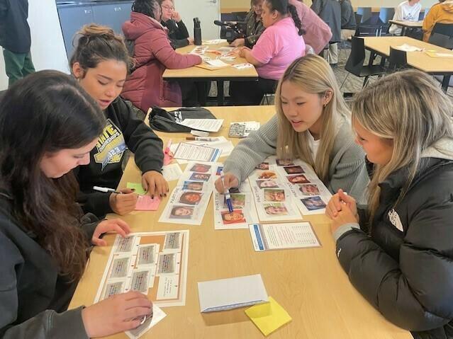 High school students taking part in the University of Washington's annual MisInfo Day earlier this month. They are looking at pictures of faces to tell whether the images were created with generative AI tools or authentic.