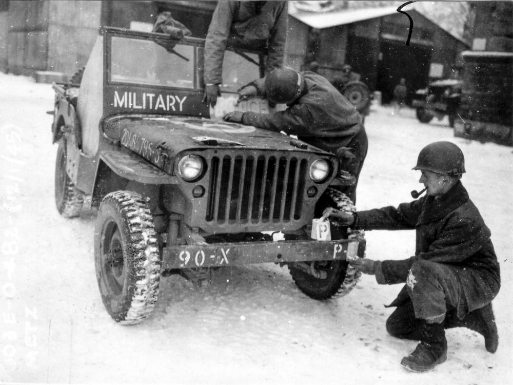 This photo provided by the Ghost Army Legacy Project shows soldiers putting new bumper markings a jeep, one of the special effects the units used towards the end of WWII to trick German troops and save American lives.
