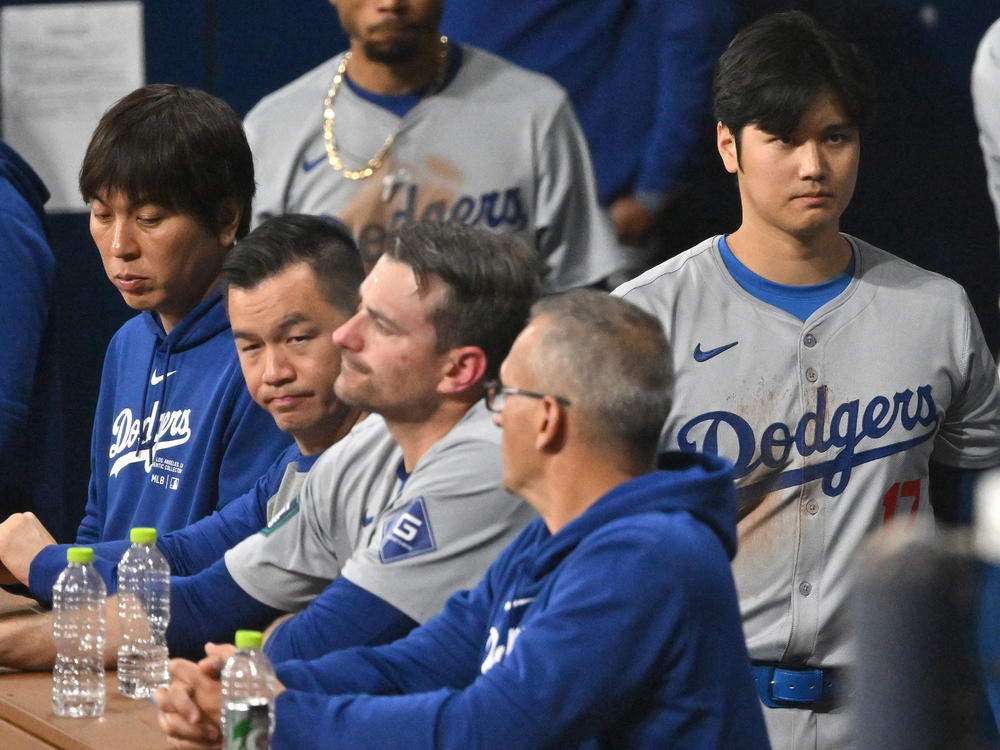 Baseball star Shohei Ohtani (right) and his interpreter, Ippei Mizuhara (left), are seen in the dugout in the 2024 MLB Seoul Series game between the Los Angeles Dodgers and the San Diego Padres. The Dodgers have fired Mizuhara after Ohtani's representatives claimed he was the victim of 