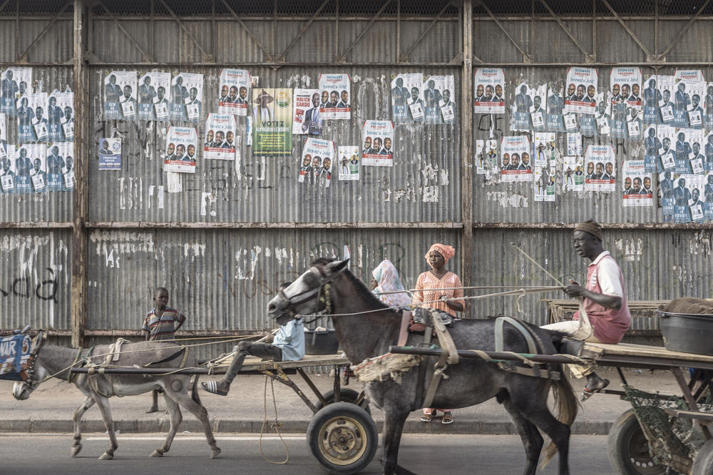 Carts ride past electoral posters in Dhara on March 21, 2024, as eighteen men and one woman are in the running on March 24 to become Senegal's fifth president.