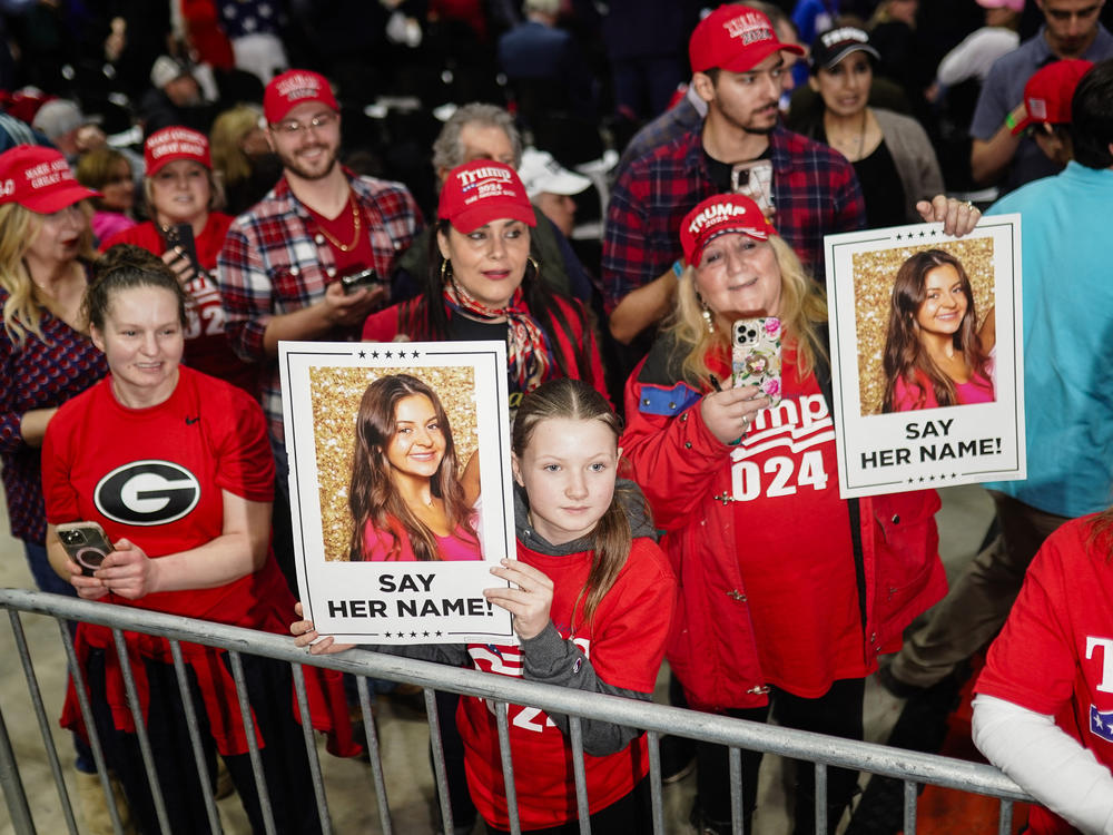 Trump supporters hold images of Laken Riley before he speaks at a rally in Rome, Ga., on March 9.