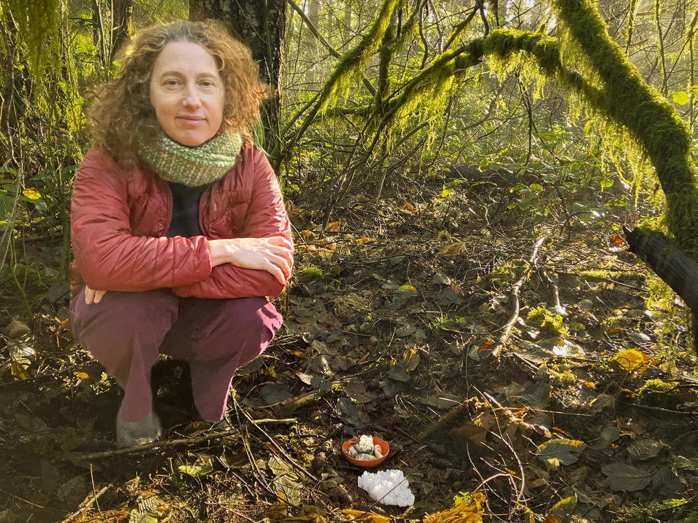 Miranda Mellis tends to an altar she built behind her home where she buried some of her father's composted remains in Olympia, Washington on Dec. 20, 2023.