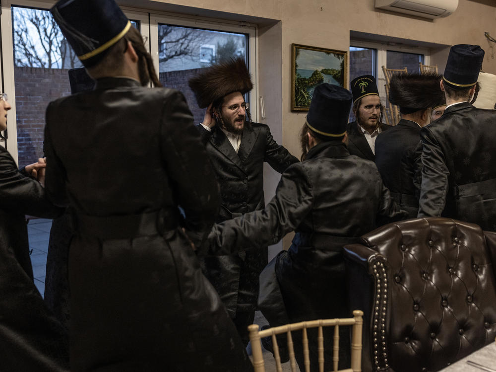 A group of Jewish boys visit homes as they gather tokens that can be exchanged for cash for their respective schools and dance during Purim on March 07, 2023 in London, England.