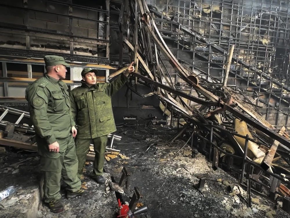 In this grab taken from video released by the Investigative Committee of Russia on Saturday, March 23, investigators from the Investigative Committee of Russia examine the burned concert hall after an attack on the Crocus City Hall outside Moscow, Russia.