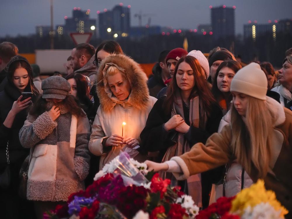 People lay flowers and light candles next to the Crocus City Hall, on the western edge of Moscow, Saturday, March 23.