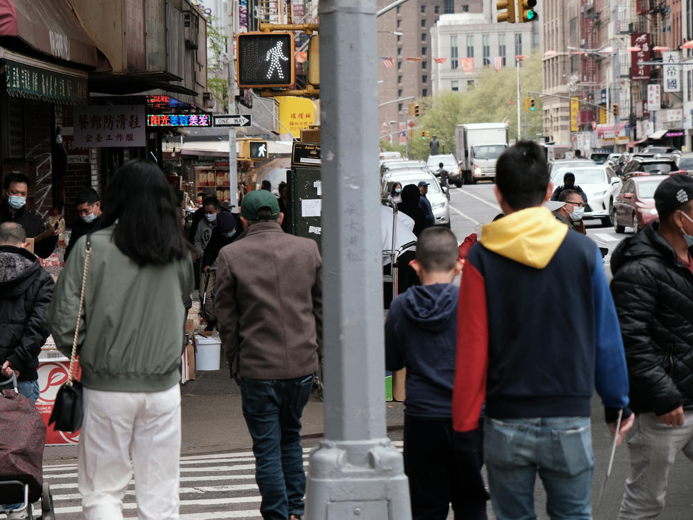 People walk through a busy street in Chinatown in New York City. About 11% of Chinese Americans live in poverty, according to a new analysis by the Pew Research Center.