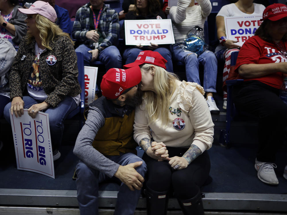 A couple kisses while waiting for the start of a campaign rally with former President Donald Trump on March 9 in Rome, Ga.