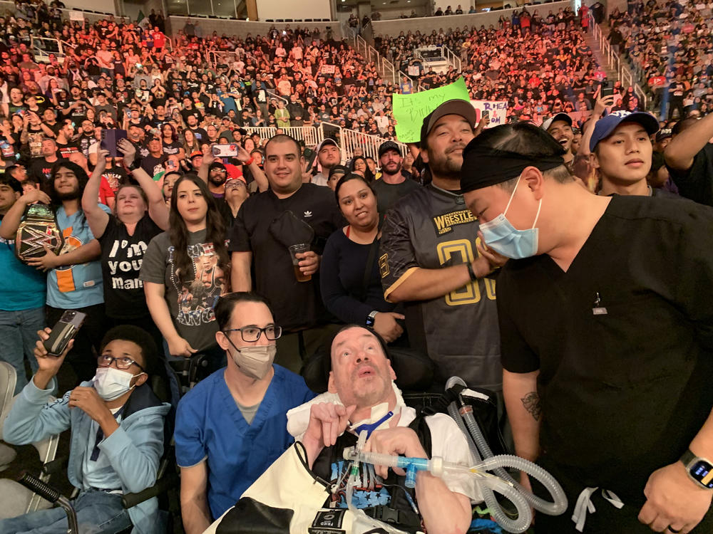Kevin Carlson enjoys the wrestling match in San Jose with a nurse and respiratory therapist.