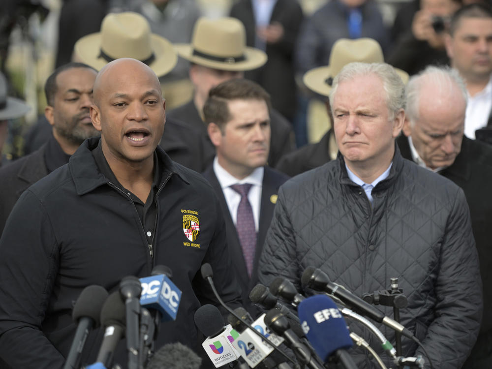 Maryland Gov. Wes Moore, left, speaks during a news conference as Sen. Chris Van Hollen (D-Md.) looks on near the scene where a container ship collided with a support on the Francis Scott Key Bridge.