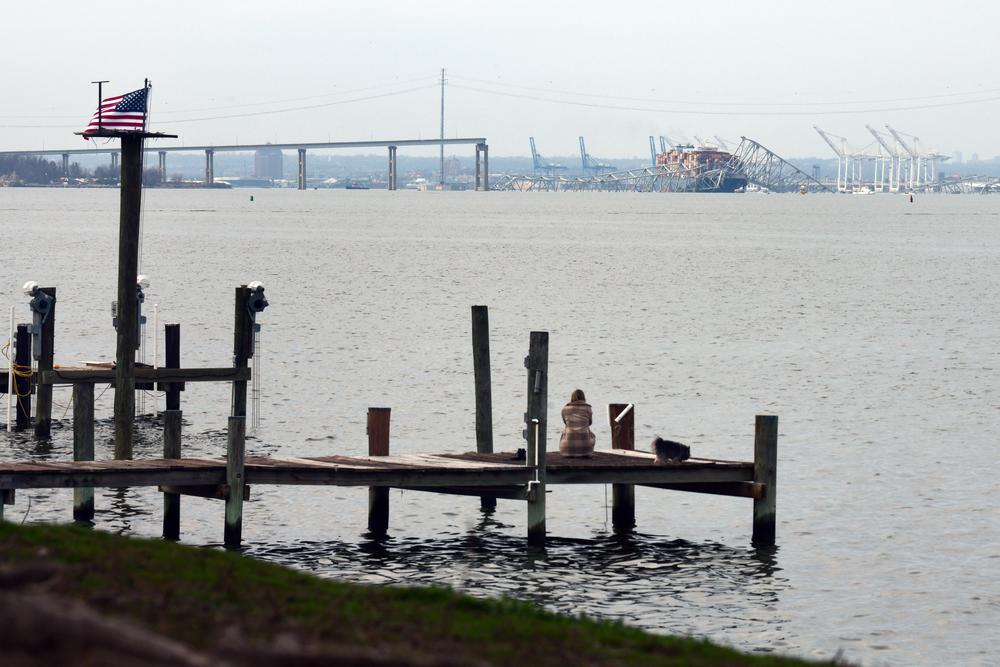 A resident of Riviera Beach looks towards the Francis Scott Key Bridge that collapsed after being hit by the Dali.