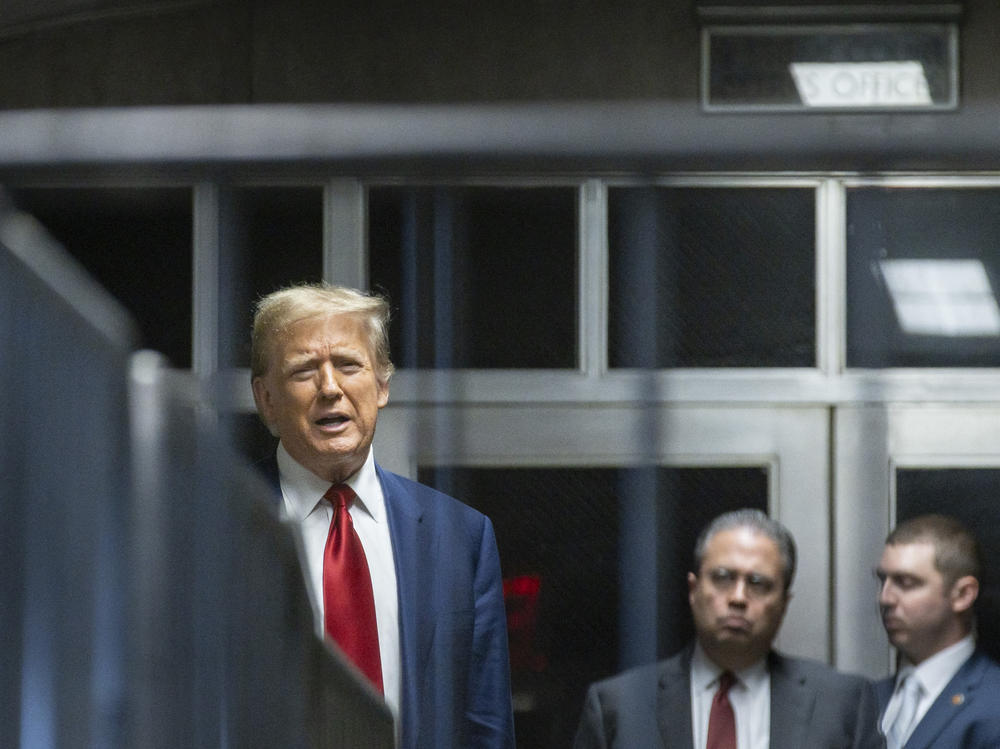 Former President Donald Trump speaks to the press in a hallway outside the courtroom at the end of a hearing to determine the date of his trial for allegedly covering up hush money payments linked to extramarital affairs, at Manhattan Criminal Court in New York City on March 25.