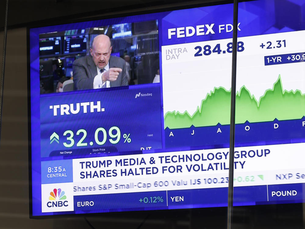 News of Trump Media & Technology Group public trading is seen on television screens at the Nasdaq Marketplace on March 26, 2024 in New York City. At one point, the company was valued at over $9 billion after trading began.