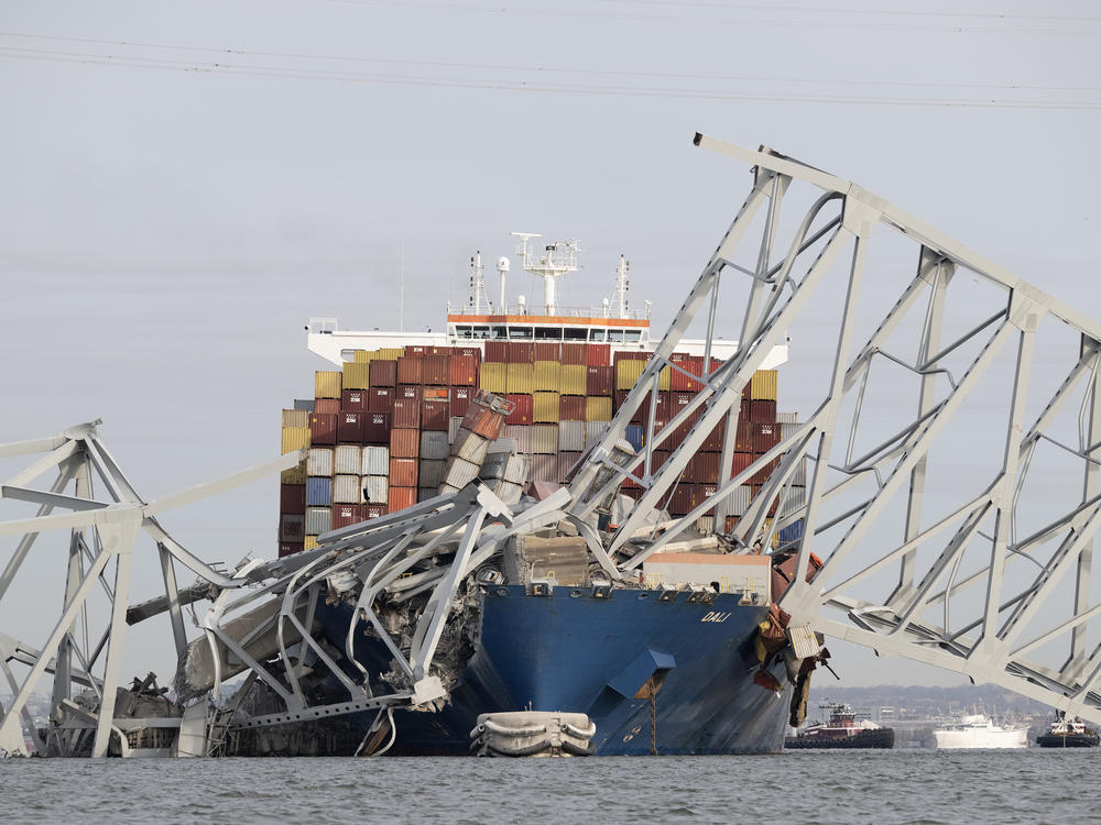The steel frame of the Francis Scott Key Bridge sits on top of the container ship Dali after the bridge collapsed in Baltimore, Md., on Tuesday. <a href=