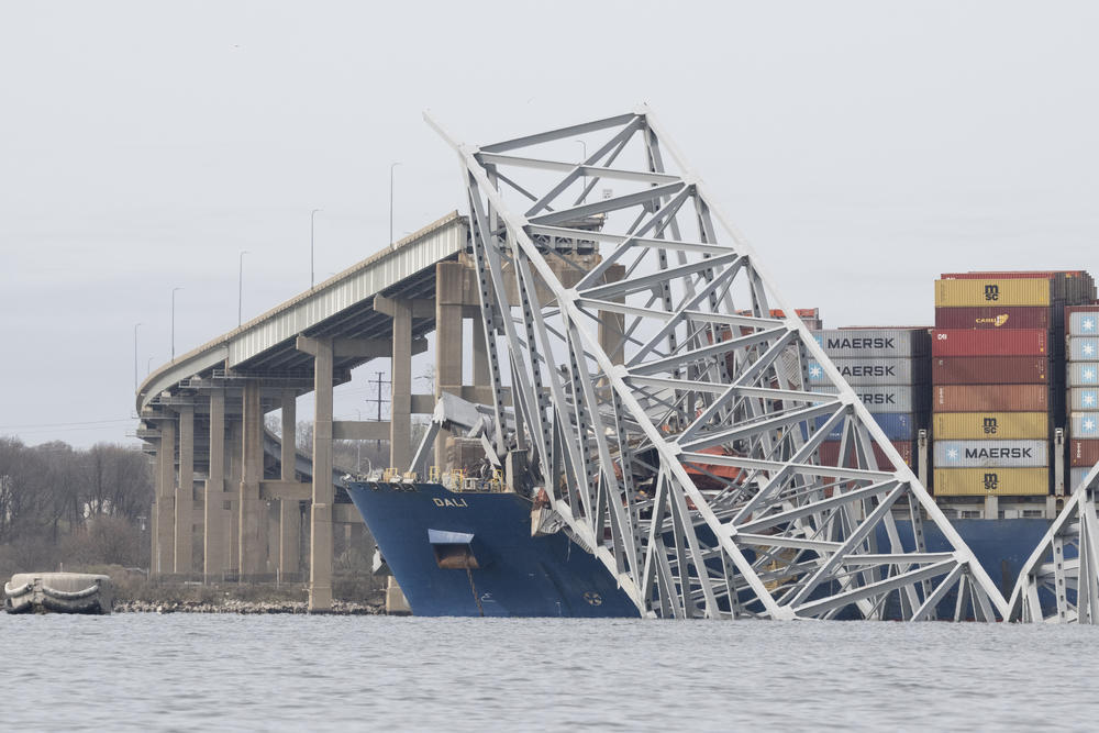 The steel frame of the Francis Scott Key Bridge sits on top of the container ship Dali after the bridge collapsed.<a href=