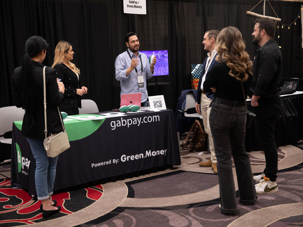 Dan Eddy (center) speaks to attendees at the GabPay booth.