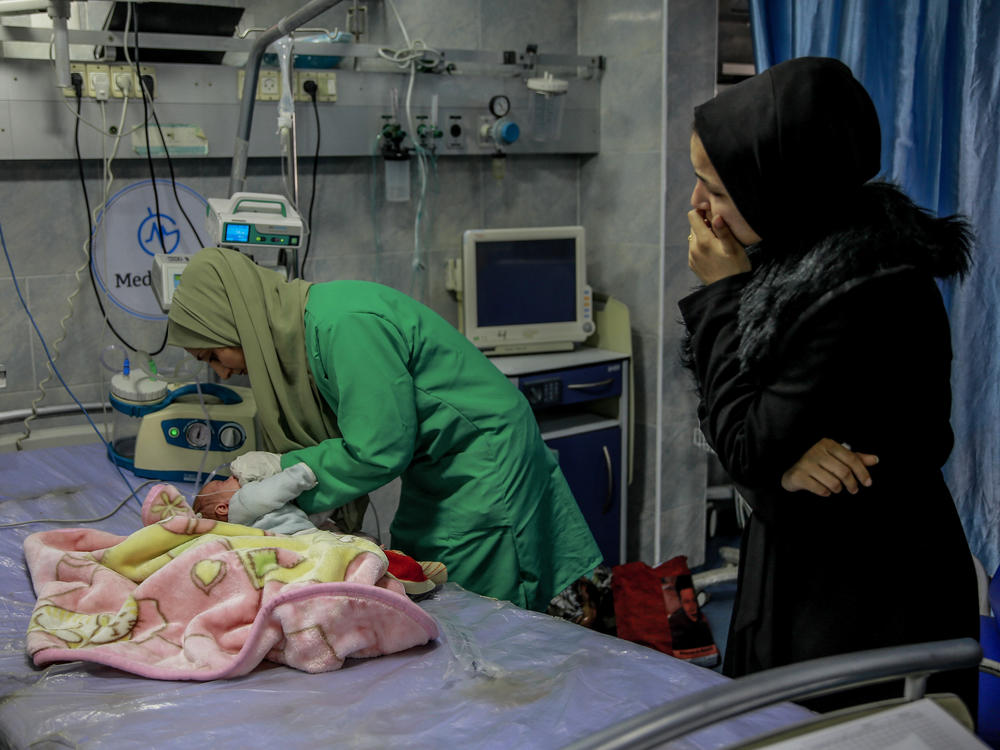 A nurse tends to a baby at Kamal Adhwan hospital in Beit Lahia, Gaza.