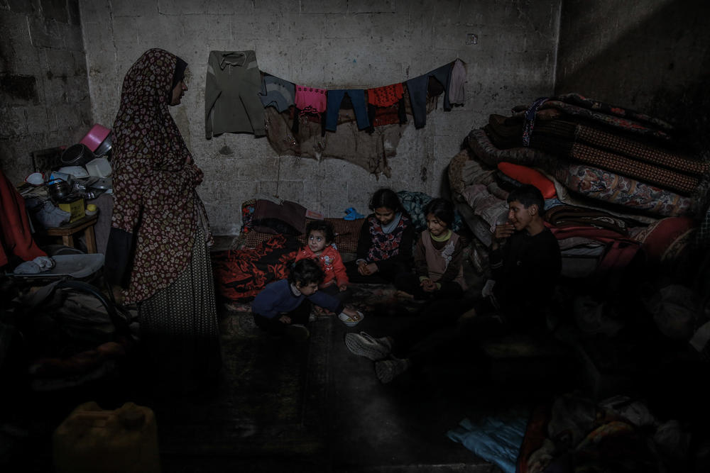 Zahia Al Sheik and her grandkids are in their damaged home in Gaza City's Al Daraj neighborhood, in northern Gaza. The children eat from a bowl of chopped-up lemons, all they had to eat in their home.