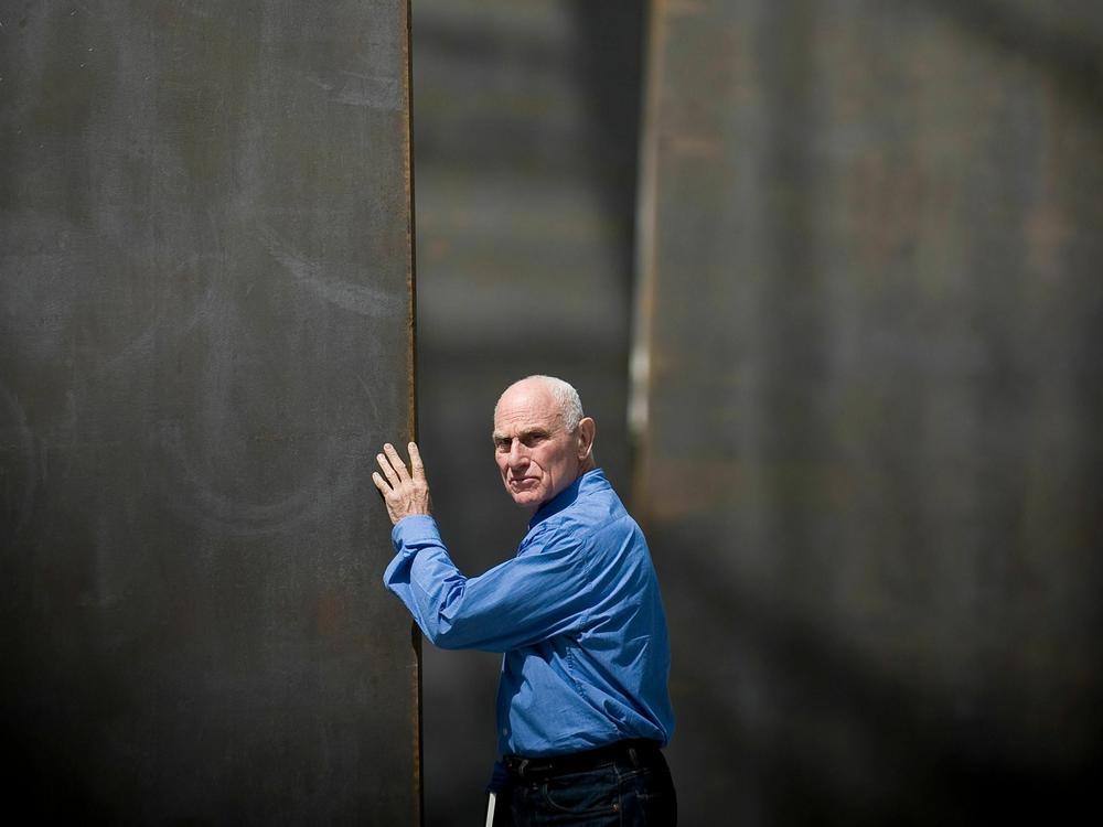 US sculptor Richard Serra poses beside one of his five massive steel sculptures or walls of steel, each piece weighing 75 tonnes, on May 04, 2008 in Paris, two day before the opening of his exhibition within the framework of Monumenta exhibition 2008 in the Grand Palais.