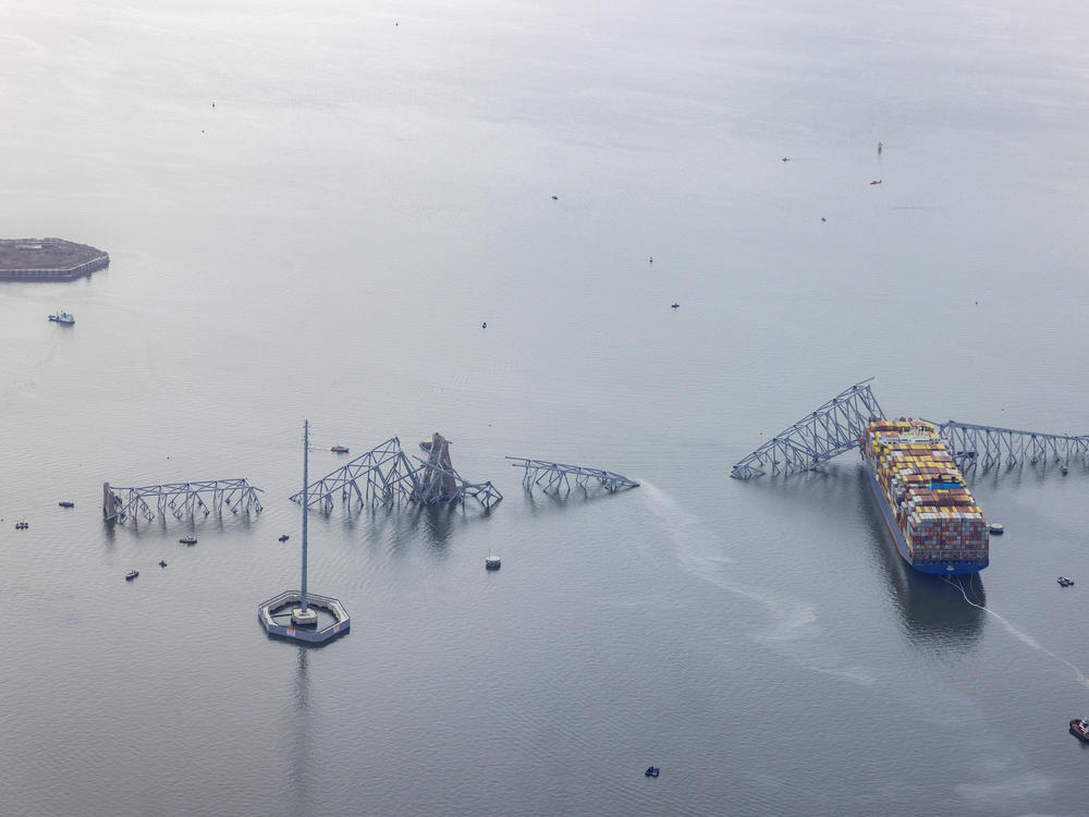 An aerial view of the cargo ship the Dali and pieces of the Key Bridge after its collapse on Tuesday. The hexagonal island of Fort Carroll can be seen on the left.