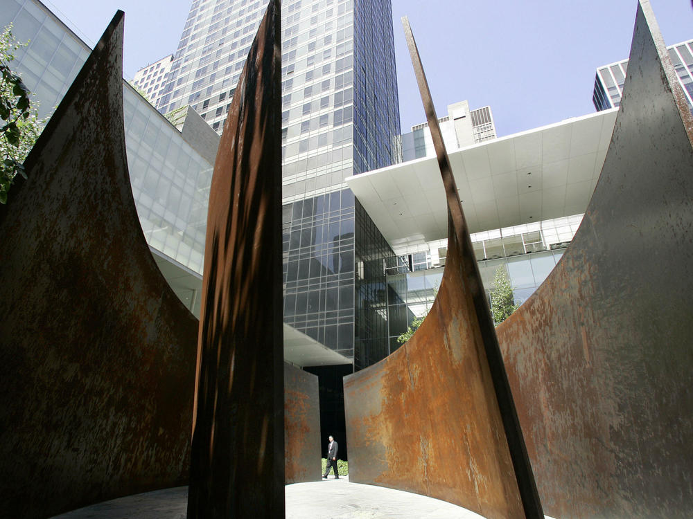 Members of the press walk through the sculpture titled 