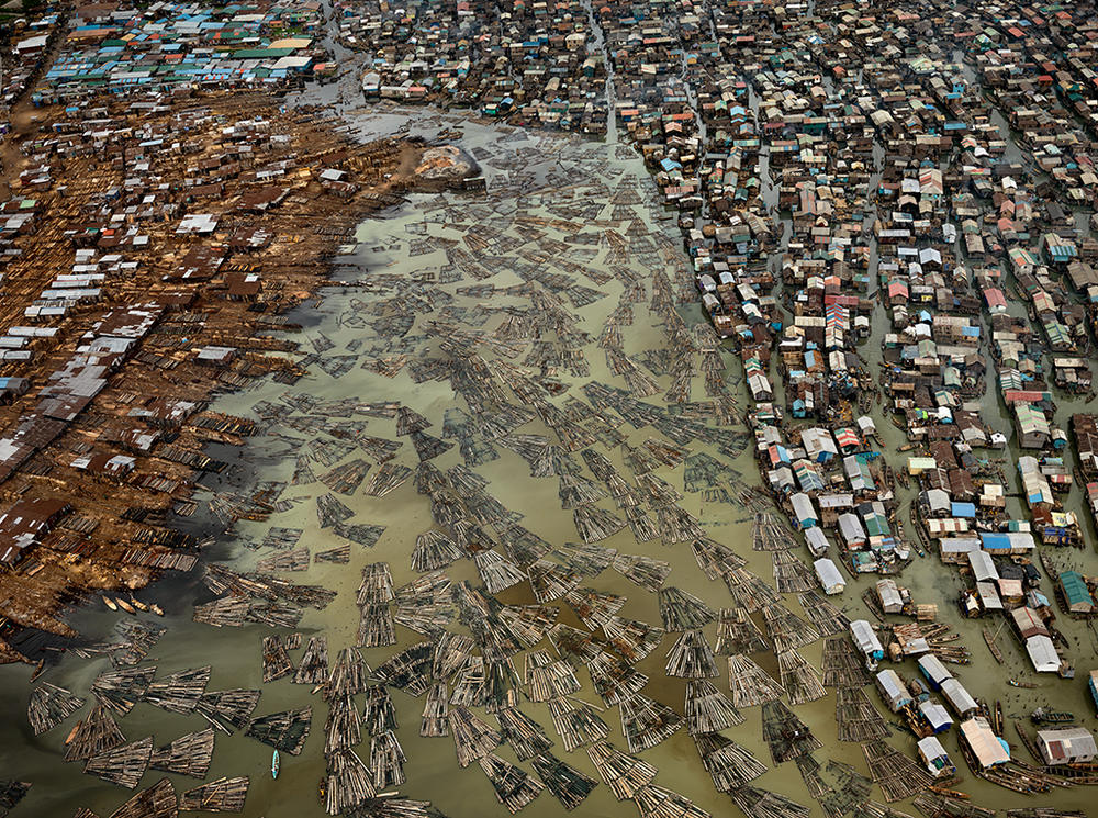 This aerial photo depicts the sawmills of Lagos, Nigeria. The timber from the country's rainforests, some of the most heavily deforested in the world, are processed in this coastal city, polluting the lagoons.
