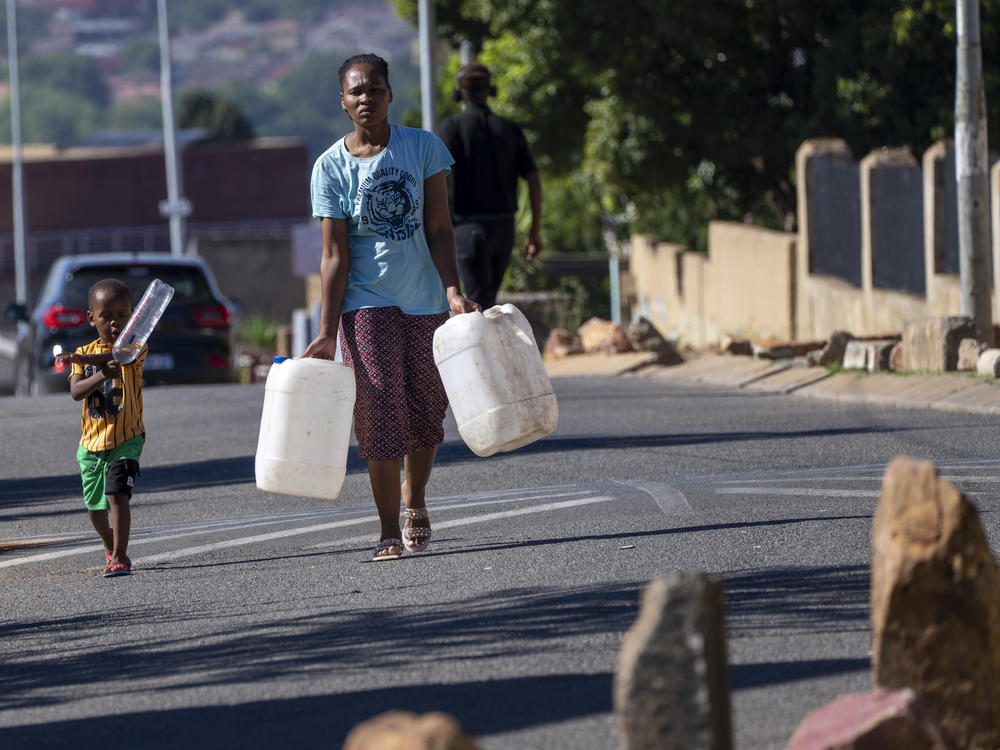 Soweto residents carry jugs and bottles to fill up with water, March 16.