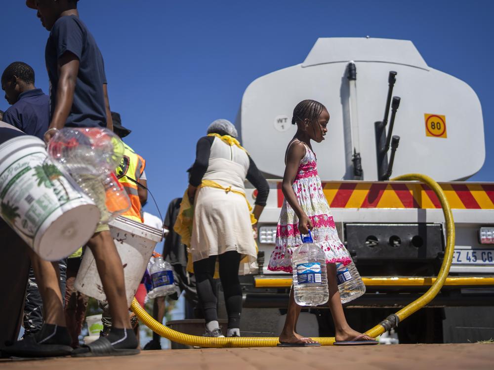 Residents of the township of Soweto, South Africa, try to get water on March 16.