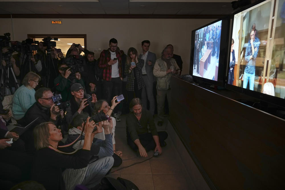 Journalists watch a TV screen broadcasting a hearing on <em>Wall Street Journal</em> reporter Evan Gershkovich's case from a courtroom at the Moscow City Court on April 18, 2023.