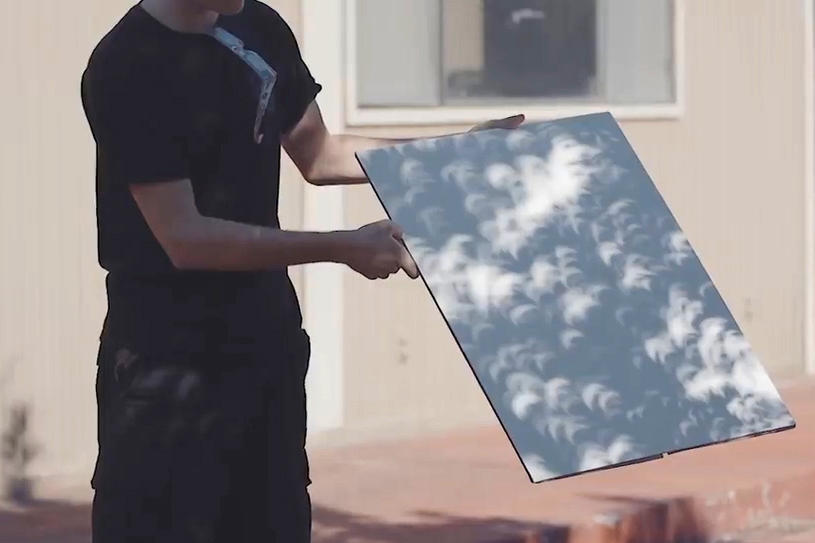 Crescent-shaped shadows cast by the solar eclipse before it reaches totality appear on a board at an eclipse-viewing event in Antelope, Ore., 2017.