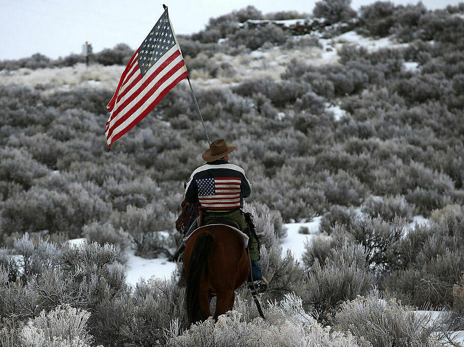 Dwayne Ehmer carries a U.S. flag as he rides his horse on the Malheur National Wildlife Refuge on Jan. 7, 2016, near Burns, Ore. An armed anti-government militia occupied the headquarters there to protest the jailing of two ranchers accused of arson.