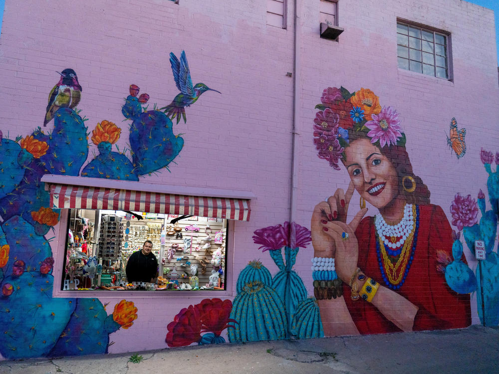 Evan Kory, one of the owners of La Cinderella and Kory bridal store, peers out of the window as the shops close in downtown Nogales.
