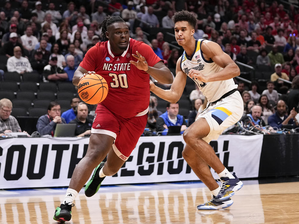 North Carolina State's DJ Burns Jr. (left) drives against Marquette's Oso Ighodaro during their Sweet 16 game in the men's NCAA Tournament in Dallas on Friday.