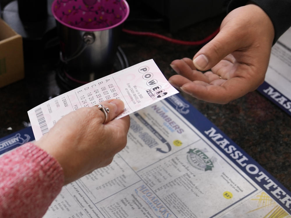A customer purchases five Powerball tickets at a lottery agent, Tuesday, Oct. 10, 2023, in Haverhill, Mass.