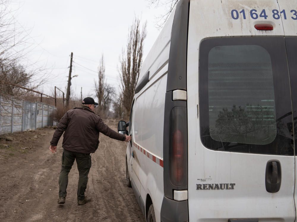Chaus returns to his van to visit more residents who are still living in his hometown, despite nearby explosions from the war's front line.