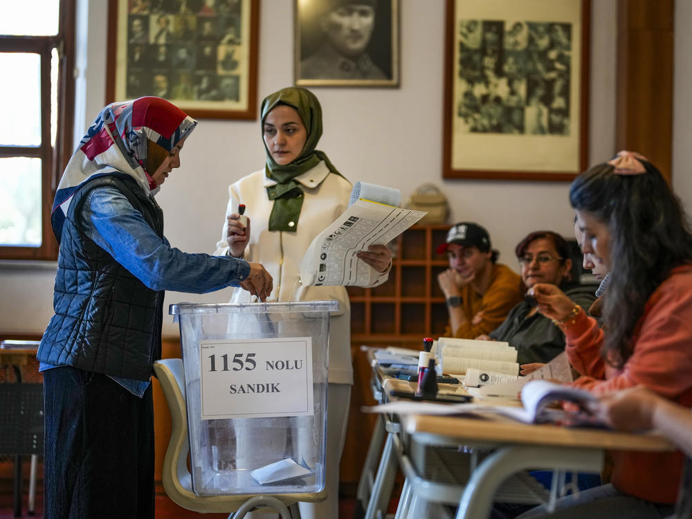 A woman votes at a polling station in Istanbul, Turkey, Sunday, March 31, 2024.