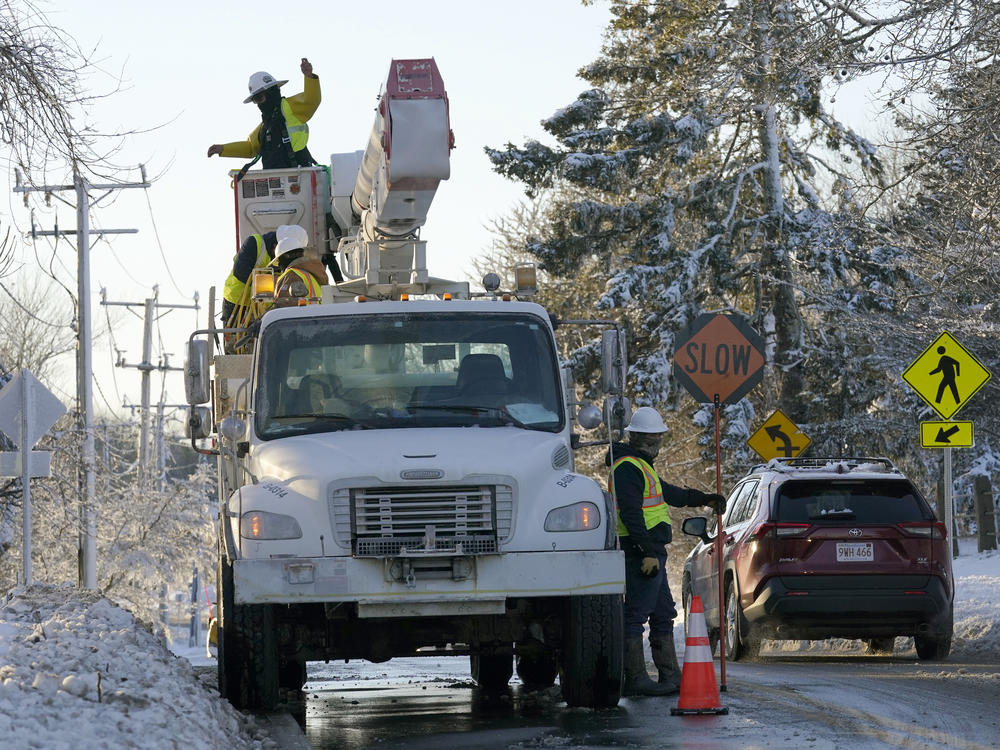 Trucks with cherry pickers, are used to repair damaged power lines, Sunday, Jan. 30, 2022, in Chatham, Mass.