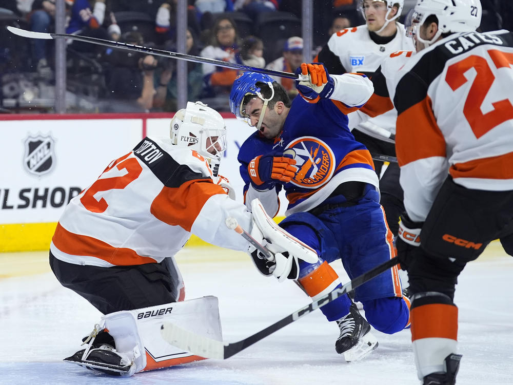 New York Islanders' Kyle Palmieri, center, collides with Philadelphia Flyers' Ivan Fedotov, left, during the third period of an NHL hockey game, Monday, April 1, 2024, in Philadelphia.