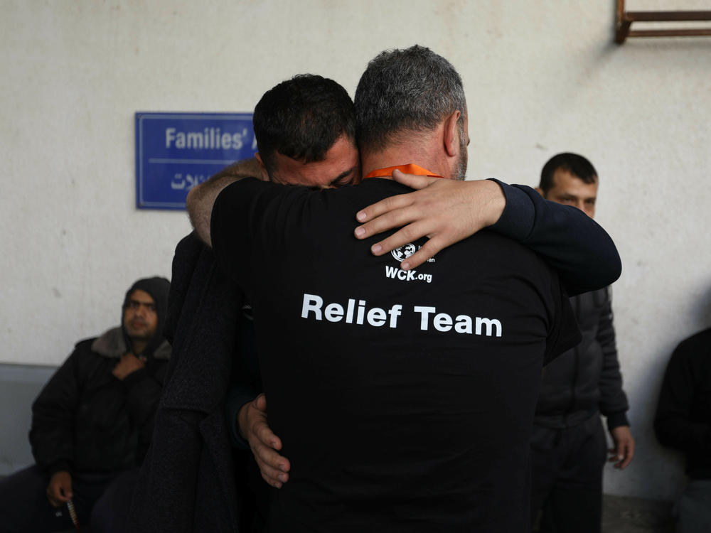 Workers hug on Tuesday after recovering the bodies of World Central Kitchen staff who were killed by Israeli air strikes in Rafah, Gaza.