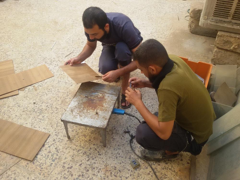 Two of Mokdad's cousins help him build his new instrument, which he named 