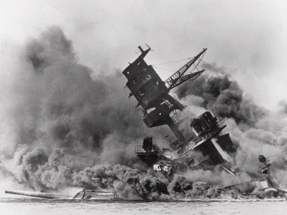 The battleship USS Arizona belches smoke as it topples over during the Japanese surprise attack on Pearl Harbor, Hawaii, on Dec. 7, 1941. The attack drew the U.S. into World War II.