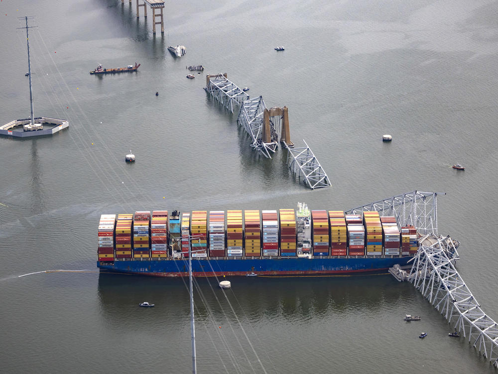 The cargo ship Dali sits in the water, surrounded by four concrete dolphins, after running into and collapsing the Francis Scott Key Bridge on March 26, 2024, in Baltimore.