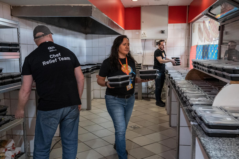 Zomi Frankcom works with colleagues and volunteers to unload and arrange for distribution lunch casseroles <a href=