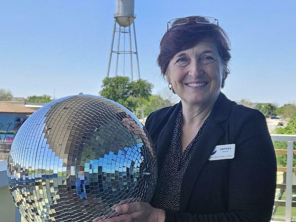 Andrea Warkentin poses with a disco ball at the Round Rock Public Library in Round Rock Texas, which tested out disco balls as projection devices during an October 2023 eclipse.