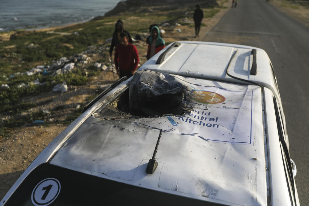 Palestinians inspect a vehicle with the logo of the World Central Kitchen, wrecked by an Israeli airstrike in Deir al Balah, Gaza Strip, April 2. A series of airstrikes killed seven aid workers from the international charity, leading it to suspend delivery Tuesday of vital food aid to Gaza.