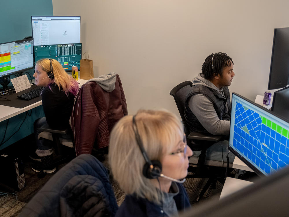 Emergency communications technicians-in-training Sarah Plopper, left, Barbara Niedt, center, and Kenneth James respond to calls during a training session at Denver 911.