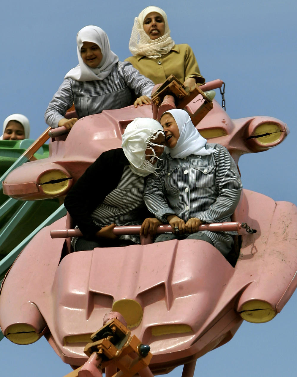 Palestinians enjoy a ride at an amusement park outside Gaza City, March 26, 2006.